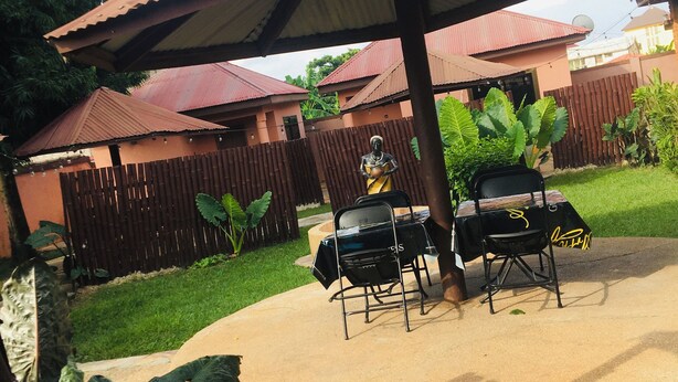 Un patio al aire libre con una zona de estar techada y una parrilla.
