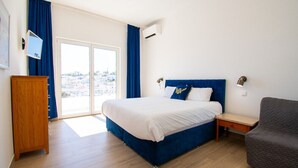 Une chambre à coucher comprenant un lit, une table de chevet, une commode et un canapé.