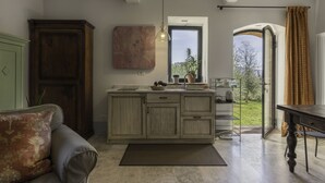 A kitchen with a large island, a dining table, and a view of the outdoors. - Lina - Podere Ribatti Casole D'elsa (Casole d'Elsa)