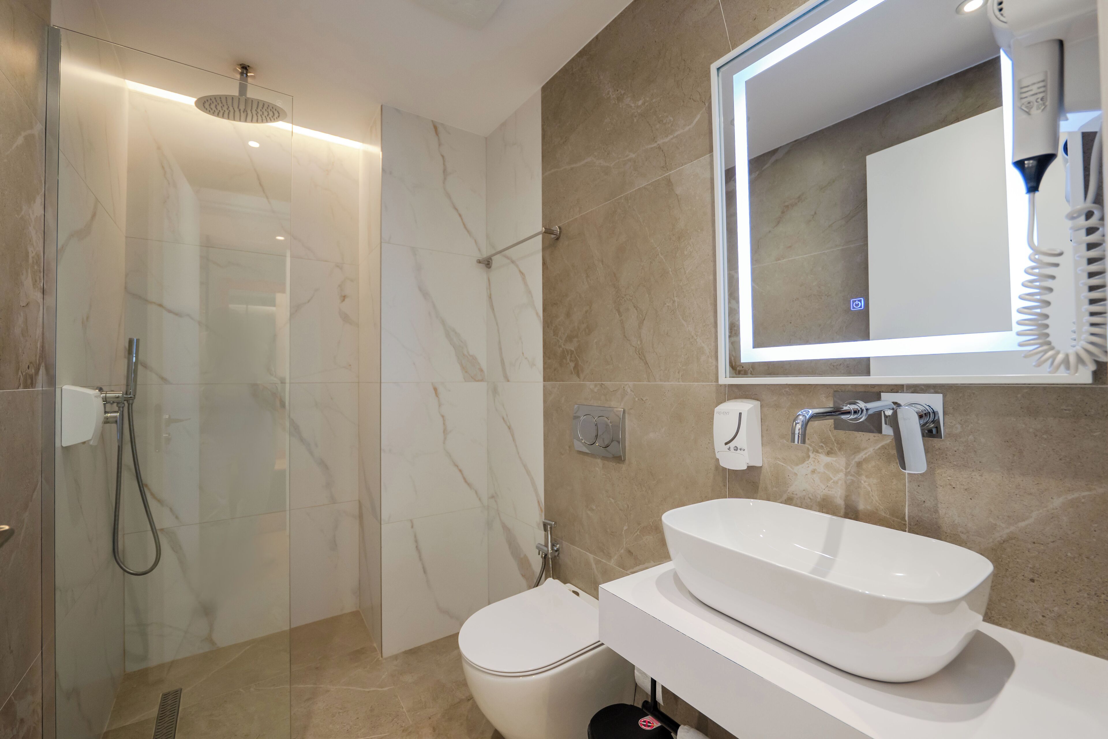 Un bagno moderno con doccia in vetro, lavandino bianco e uno specchio grande.
