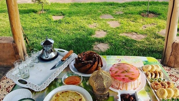 Taula de dinar amb diferents plats i una piscina al fons.