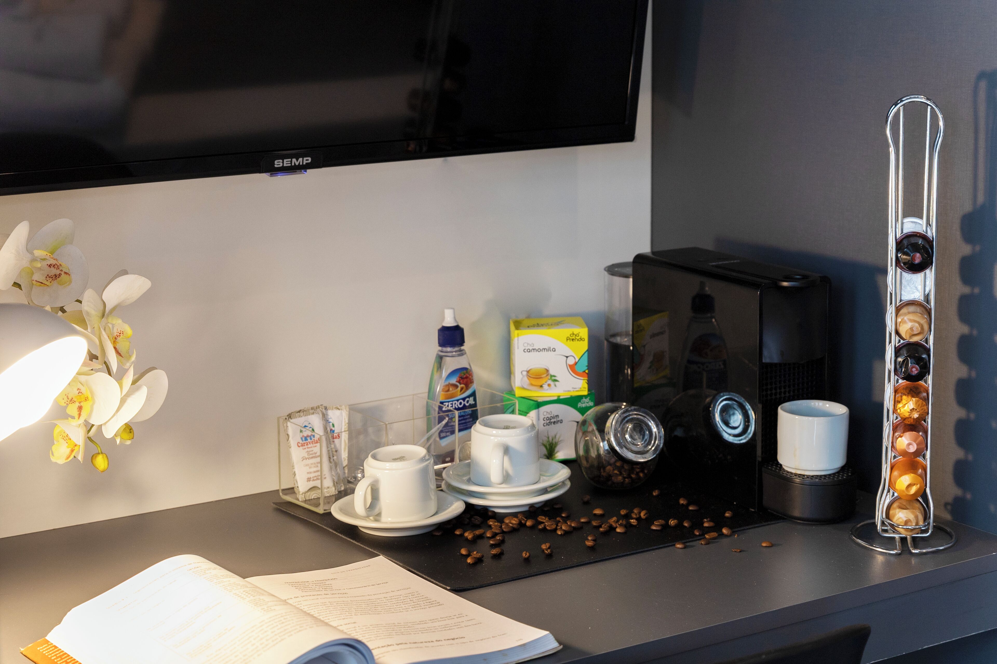 Een koffiehoek met een koffiezetapparaat, bekers en een koffieboonapparaat.