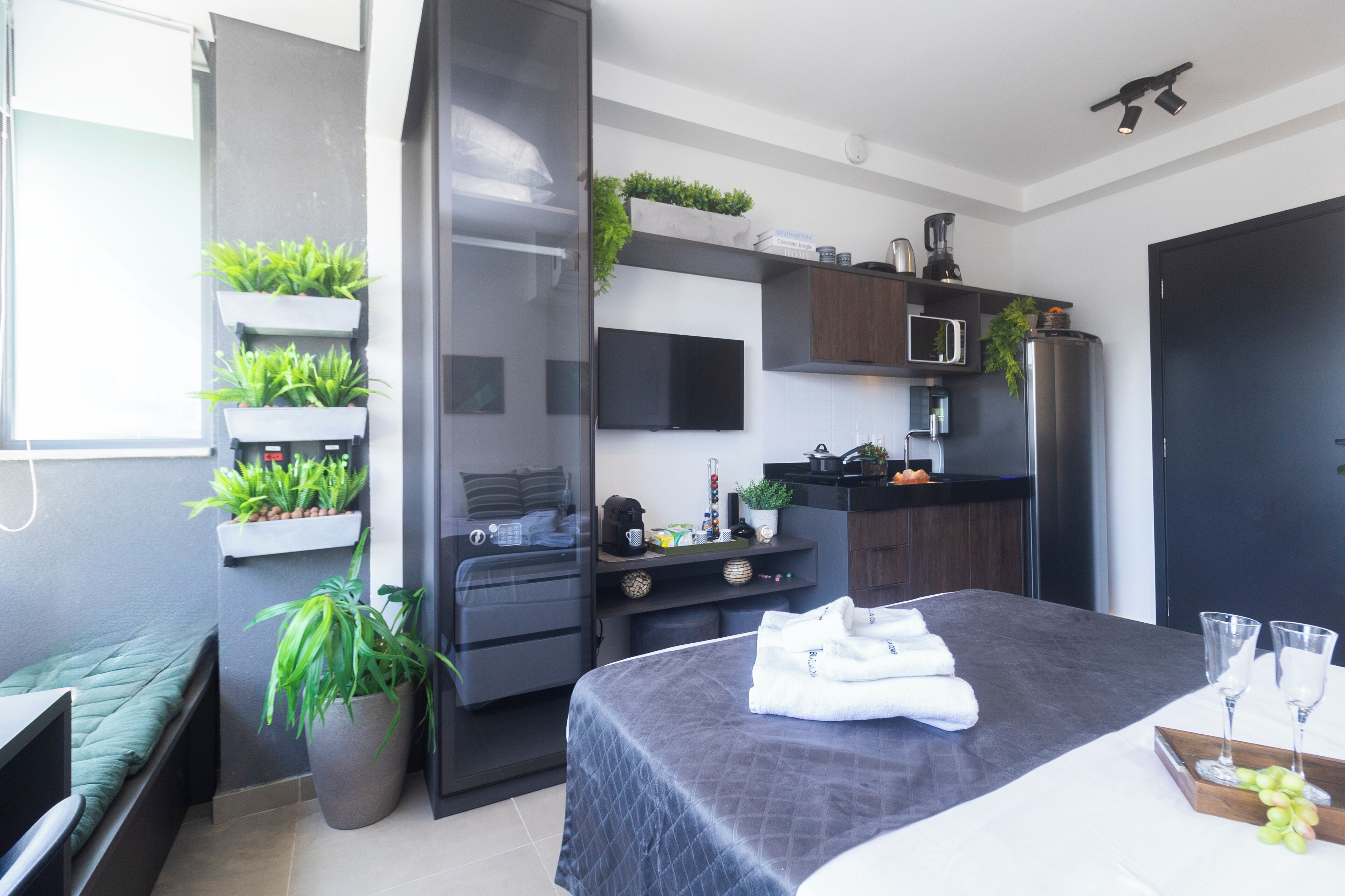 Un dormitorio moderno con cama, mesita de noche y un amplio ventanal.