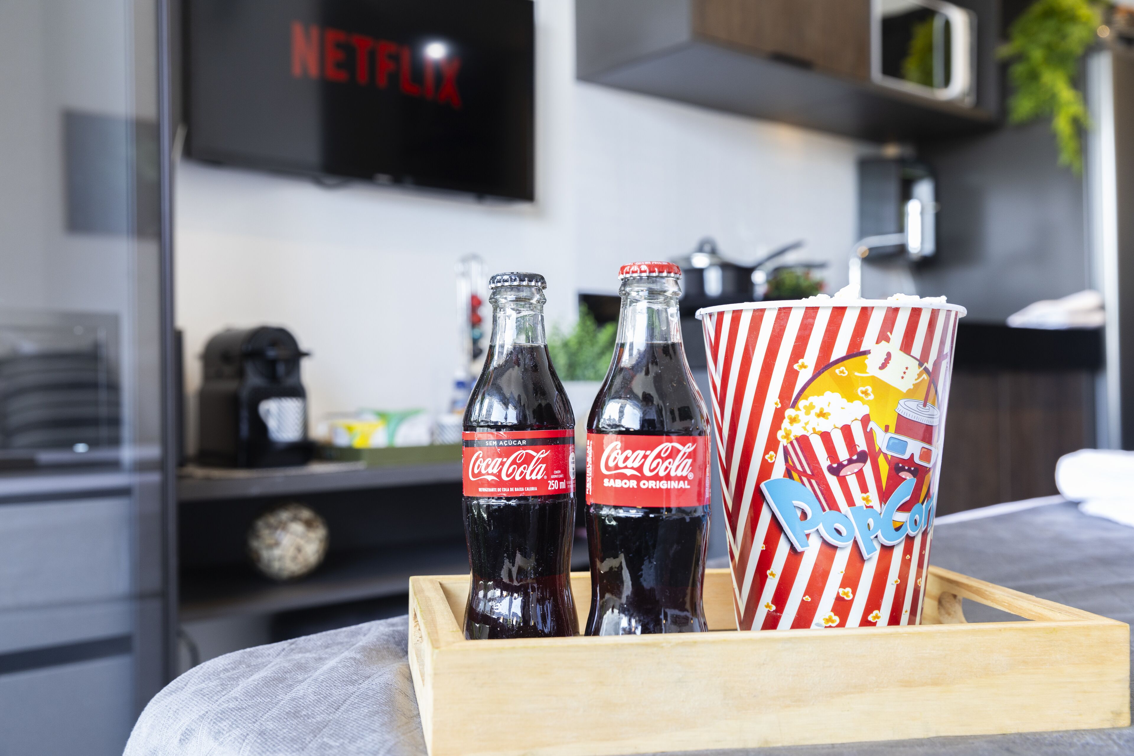 A tray with two Coca-Cola bottles and a popcorn container.