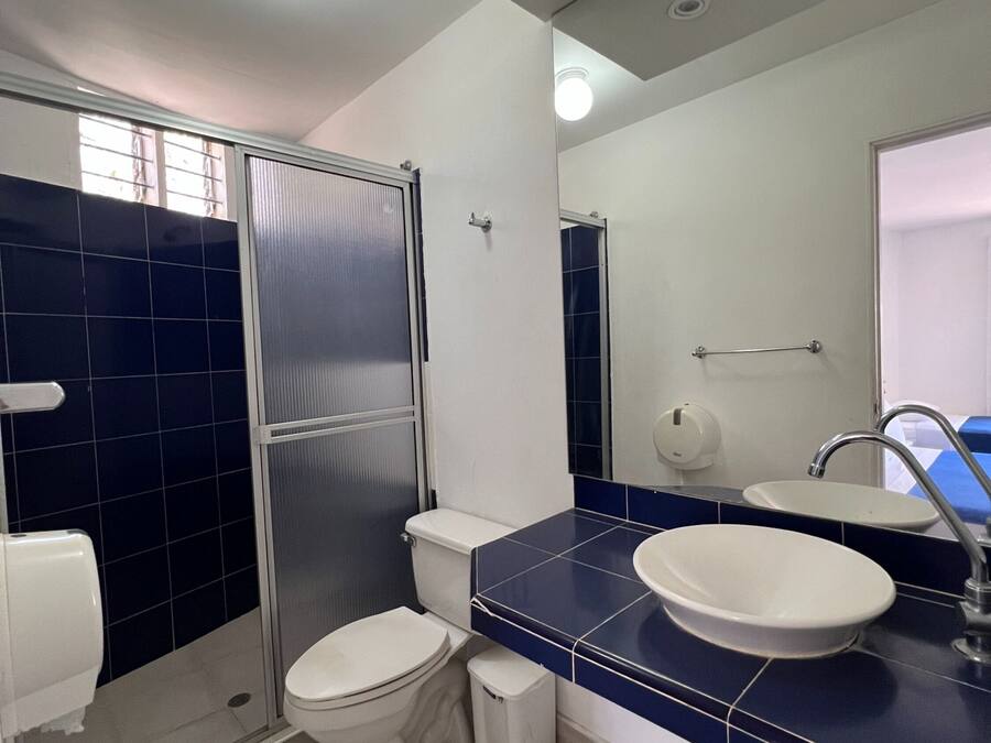 Une salle de bain moderne avec des toilettes blanches, un lavabo et un espace douche.