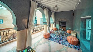 Un intérieur spacieux agrémenté d’un tapis à motifs, de grandes fenêtres et d’éléments architecturaux traditionnels.