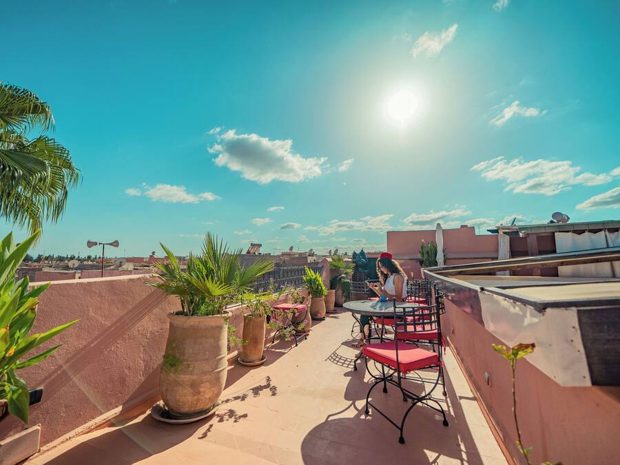 Una terrazza sul tetto con piante in vaso, posti a sedere all'aperto e una vista chiara sullo skyline della città.