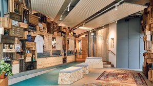 A cozy interior with wooden crates as walls, a small pool, and a patterned rug. - Villa Viva Hotel Hamburg (Hamburg)