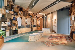 Ein gemütliches Interieur mit Wänden aus Holzkisten, einem kleinen Pool und einem gemusterten Teppich.