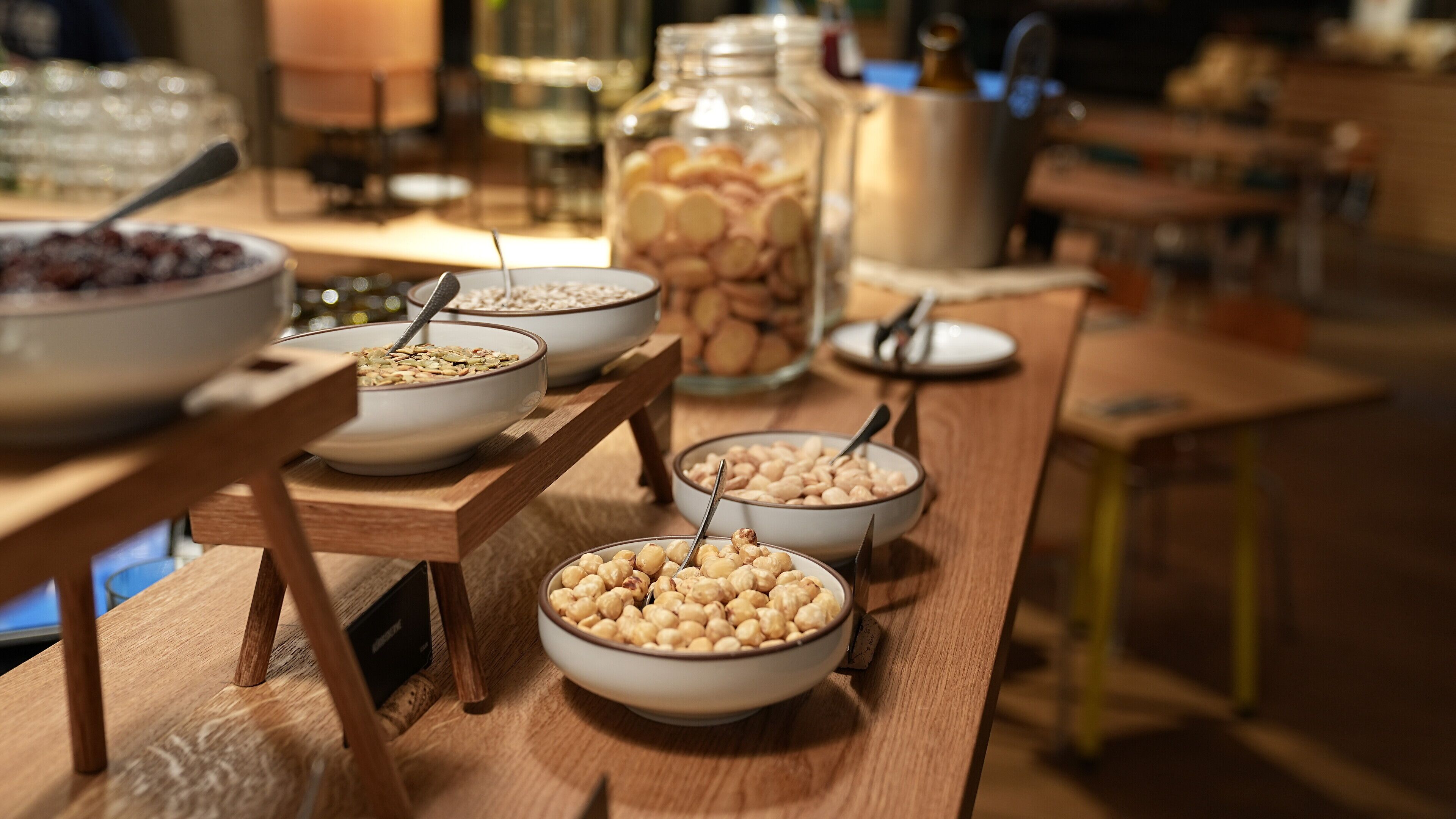 Un bufé de desayuno con diversas opciones de comida, incluyendo cereales, nueces y legumbres.