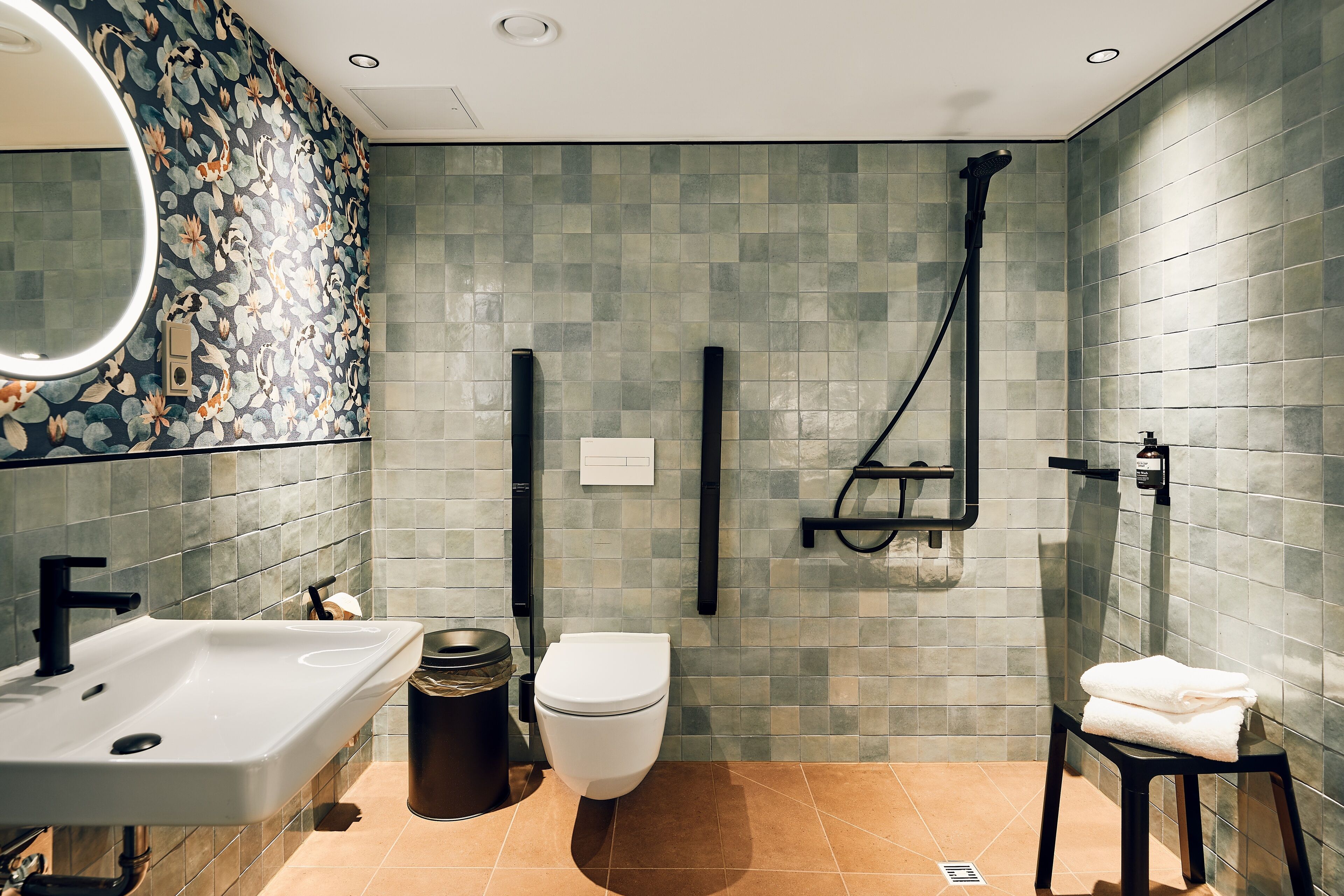 A modern bathroom with a sink, toilet, and shower.