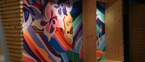 A room with a colorful abstract mural on the wall and wooden paneling.