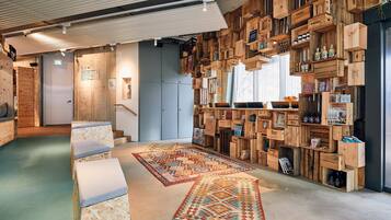 Cozy space with a unique shelving unit, wooden benches, and a patterned rug.