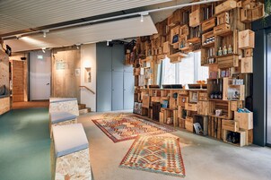 Ein gemütliches Interieur mit Holzkisten als Regale, einer Treppe und einem gemusterten Teppich.