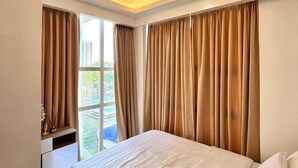 A bedroom with a bed, a window, and a ceiling light. - Escape to Paradise: Unwind in Style at our Spectacular Haven (Lapu-Lapu City)