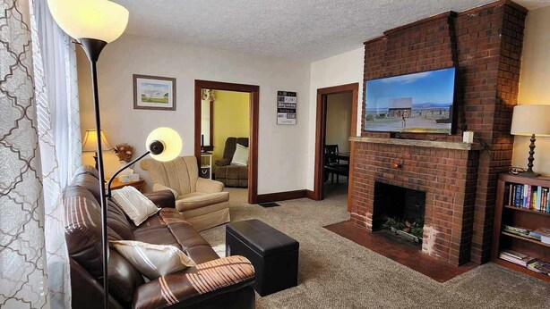 Una sala de estar con chimenea, un sofá, una mesa de centro y un televisor.
