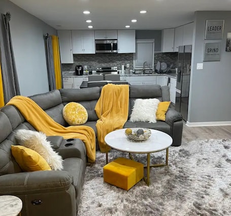 A modern living room with a sectional sofa, a round coffee table, and a fluffy rug.
