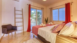 Une chambre avec un lit, une chaise, une échelle et une vue sur l’extérieur.