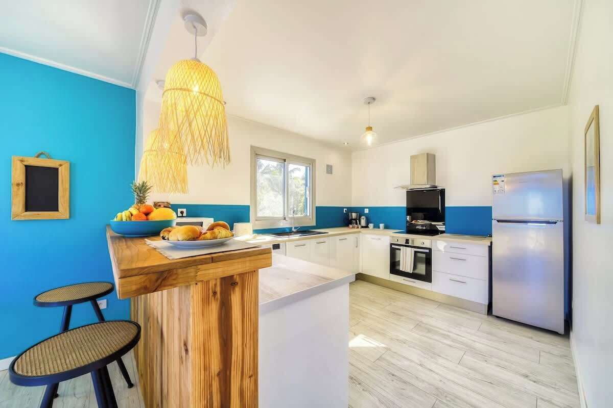 Eine moderne Küche mit einer Holztischinsel, weißen Schränken und einer blauen Akzentwand.