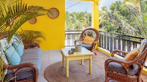 A balcony with wicker furniture, a small table, and a view of palm trees. - Kaz Zévi - Haut de Villa 4* à la Saline les Bains (Saint-Paul)