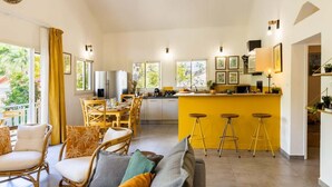 A modern living space with a dining area, kitchen, and bar area. - Kaz Zévi - Haut de Villa 4* à la Saline les Bains (Saint-Paul)