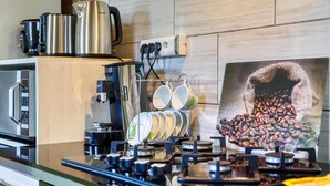 Une cuisine équipée d’une machine à café, d’un four à micro-ondes et d’un présentoir à grains de café.