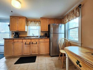 Een koelkast, kookgerei, borden en bestek