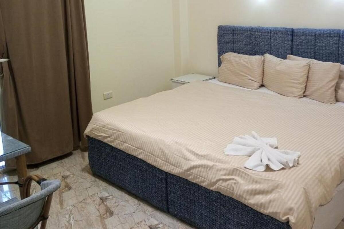 A hotel room with a bed, a desk, and a chair.