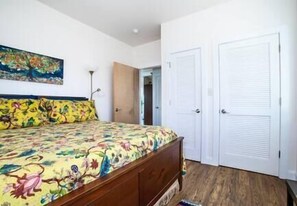 A bedroom with a bed, a wardrobe, and a door leading to another room. - Blueberry Hill Cottage, Lexington Virginia, Blueberry Hill Cottage, Lexington Virginia (Lexington)