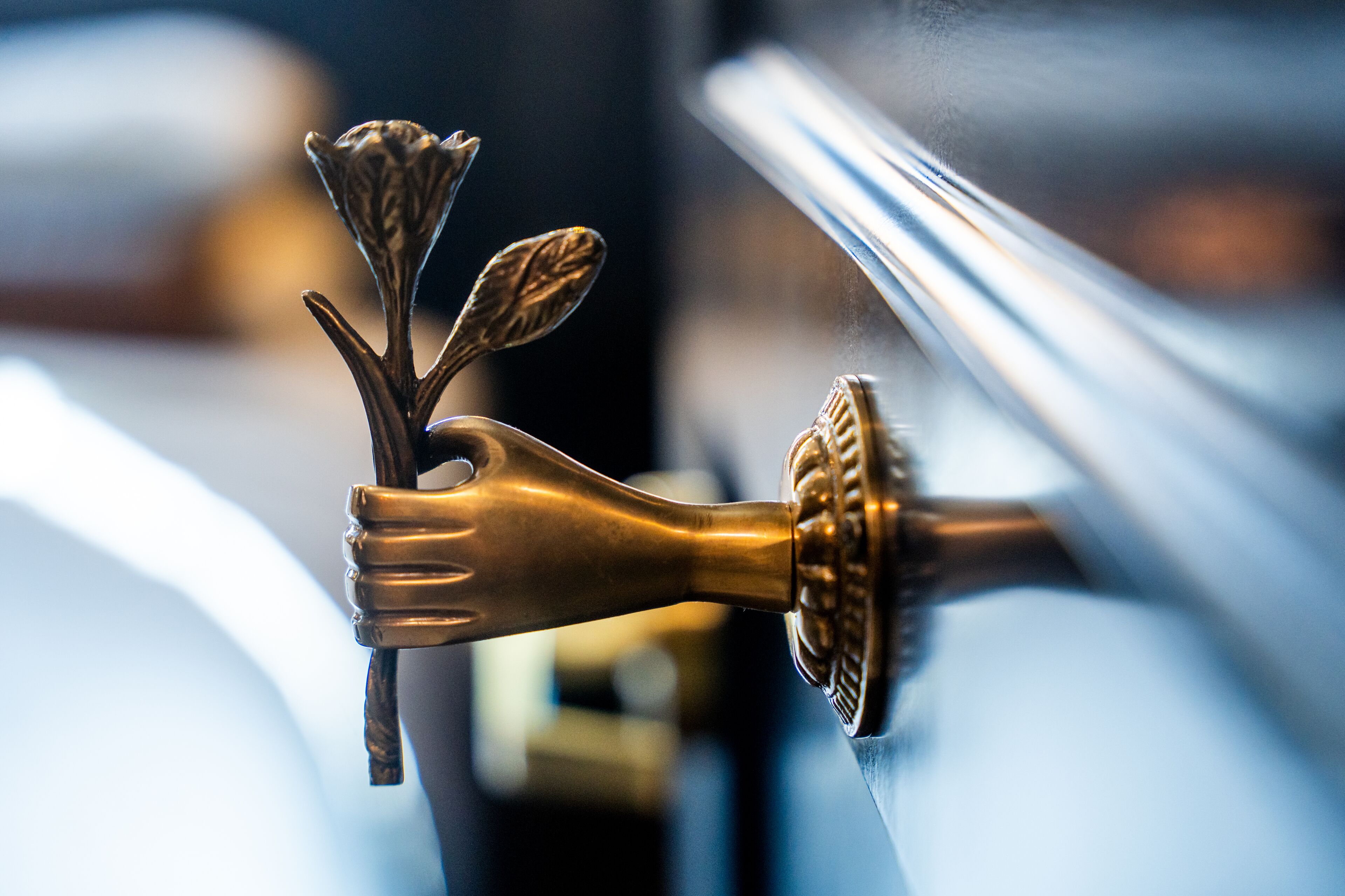 A close-up of a brass door handle with a floral design.
