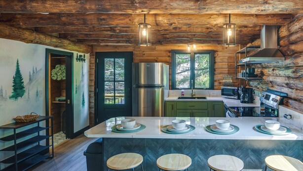 A rustic kitchen with a wooden ceiling, a stainless steel refrigerator, and a bar area with stools. - Fairhaven Harbor-Front Gem - Steps From the Water! (Fairhaven)
