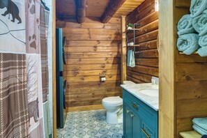 A wooden cabin bathroom with a toilet, sink, and towel rack. - Fairhaven Harbor-Front Gem - Steps From the Water! (Fairhaven)