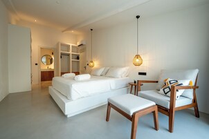 Un dormitorio moderno con una cama, una silla de madera y una mesita.