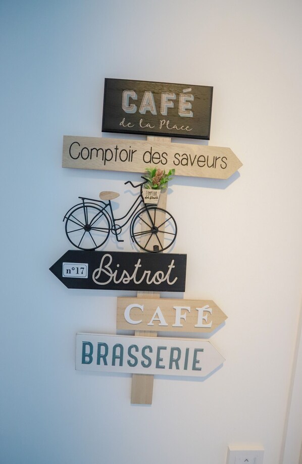 A wall with signs indicating a cafe, a bistro, and a brasserie. - L'échappée Belle (Annecy)
