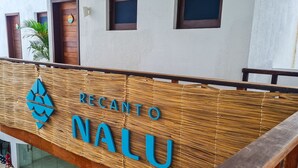A reception area with a wooden sign that reads "RECANTO NALU". - Qavi - Recanto Nalu (Tibau do Sul)