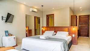 A hotel room with a bed, a desk with a computer, and a mirror. - Qavi - Recanto Nalu (Tibau do Sul)