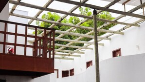 A white building with a wooden balcony and a wooden pergola. - Qavi - Recanto Nalu (Tibau do Sul)