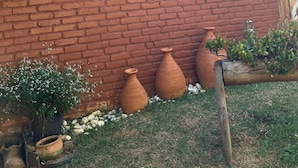 A rustic building with a wooden exterior, a large window, and several clay pots in the foreground. - Chalé Refúgio 1 (Corumba de Goias)