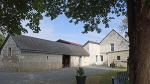 Ein Innenhof mit Steinhäusern, einem Kiesweg und einem Blumentopf.