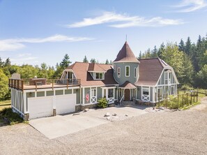 A large, multi-story house with a garage, a balcony, and a small porch area.