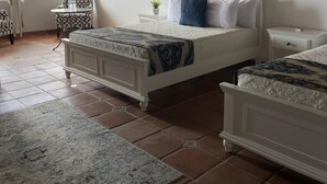 A bedroom with two beds, a small table, and a chair. - Viñas del Castillo Hotel Boutique (Ensenada)