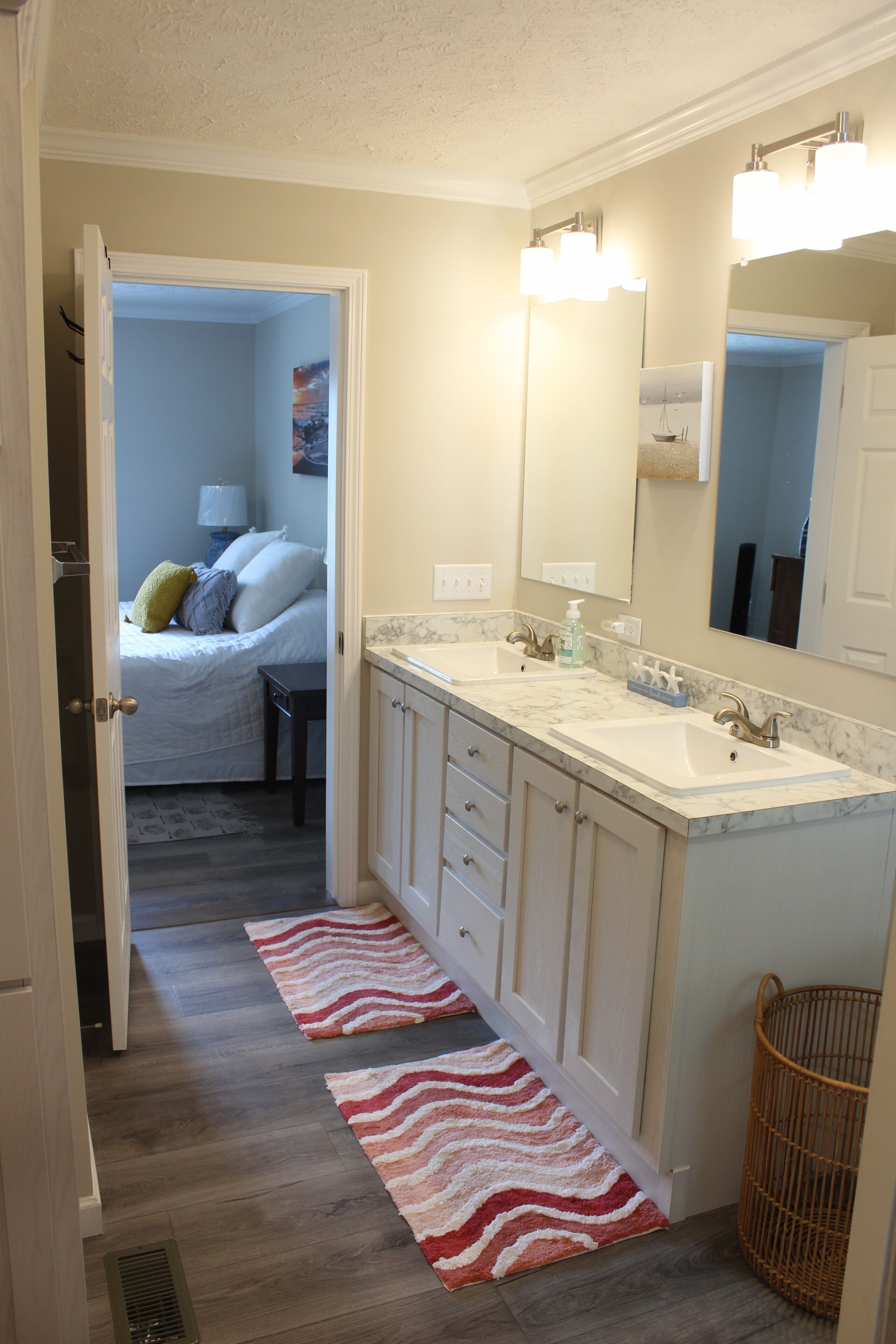 A bathroom with a double sink, a mirror, and a shower.