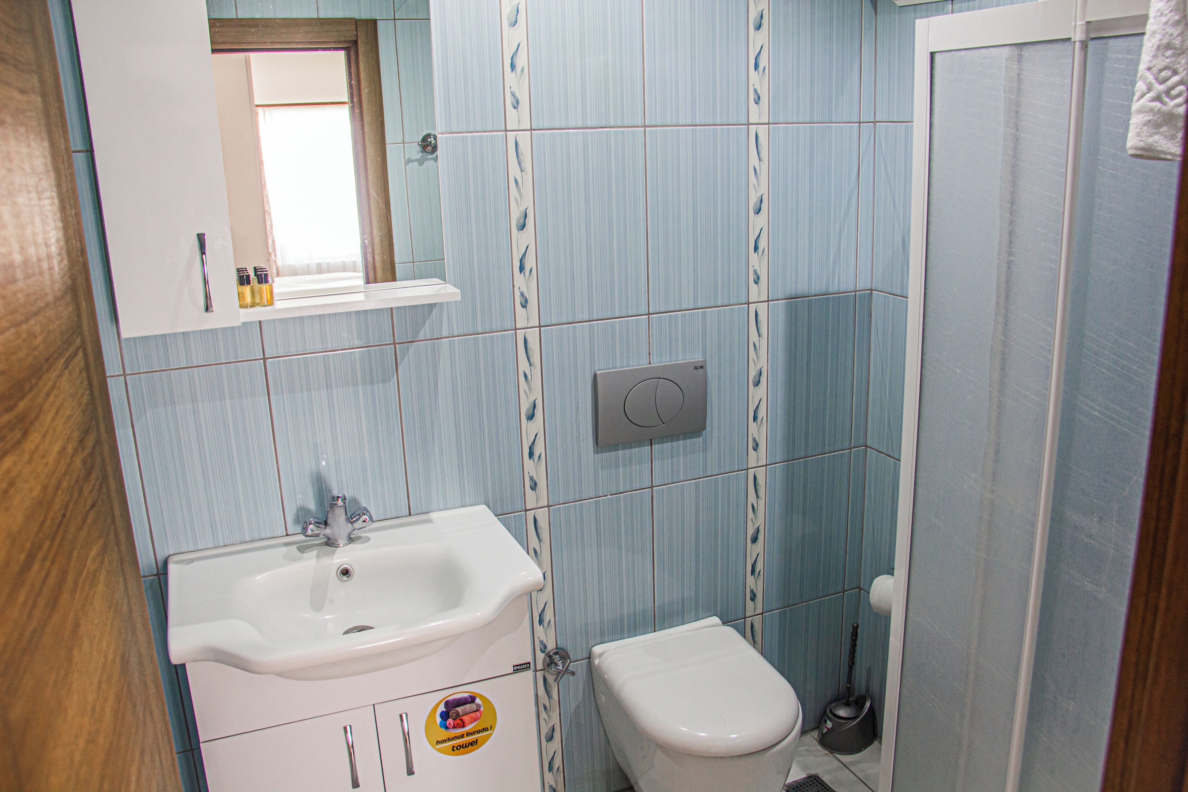 Une salle de bain avec un lavabo, des toilettes et un miroir.