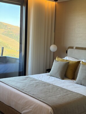 A hotel room with a large bed, a view of the countryside, and a modern lamp. - Quinta Vale de Lobos Douro (Armamar)