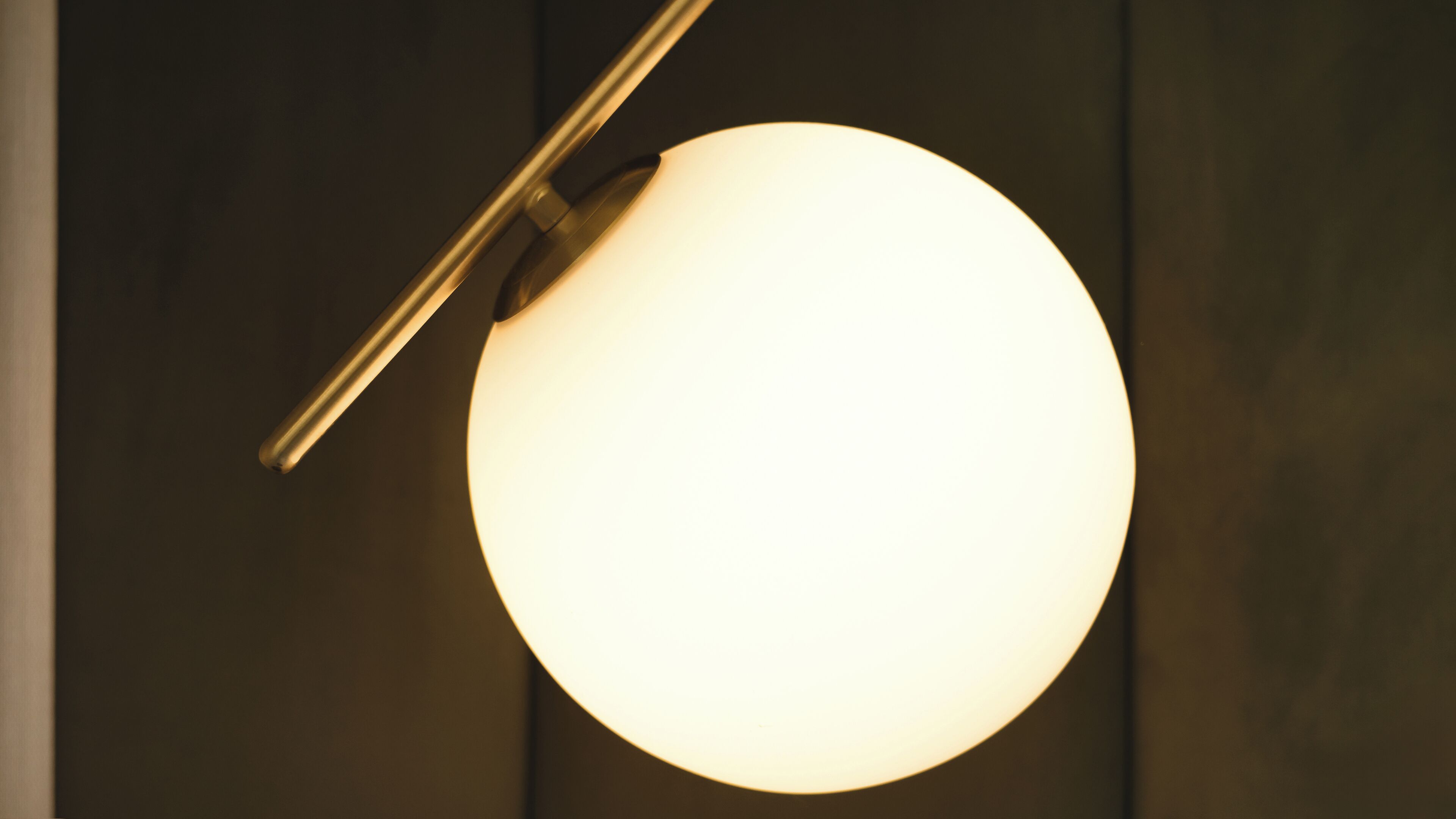A spherical light fixture with a metallic arm extending from the ceiling.