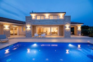 A modern house with a swimming pool, stone exterior, and outdoor seating area. - Villa Olive Garden with Pool & Seaview (Brzac (Krk))
