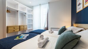 A hotel room with a large bed, two bedside tables, a wardrobe, and a window with sheer curtains. - SOUL BEACH apartment (PARKING INCLUDED) (San Sebastián/Donostia)