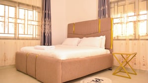 Une chambre à coucher avec un grand lit, des rideaux et une petite table.