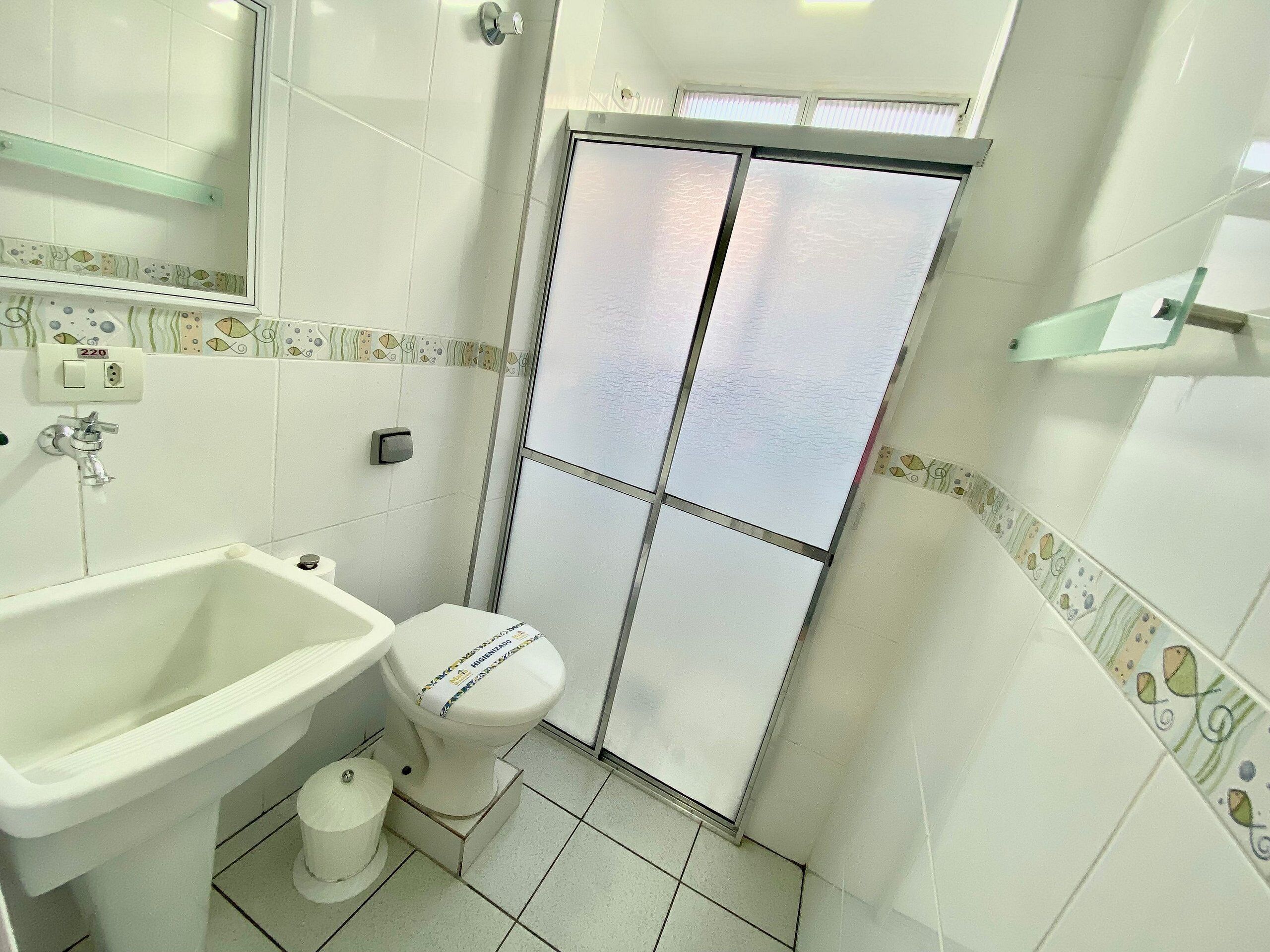 Un baño con inodoro, lavamanos y ducha.