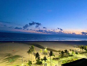 Una playa con palmeras, un parque infantil y vistas al océano.